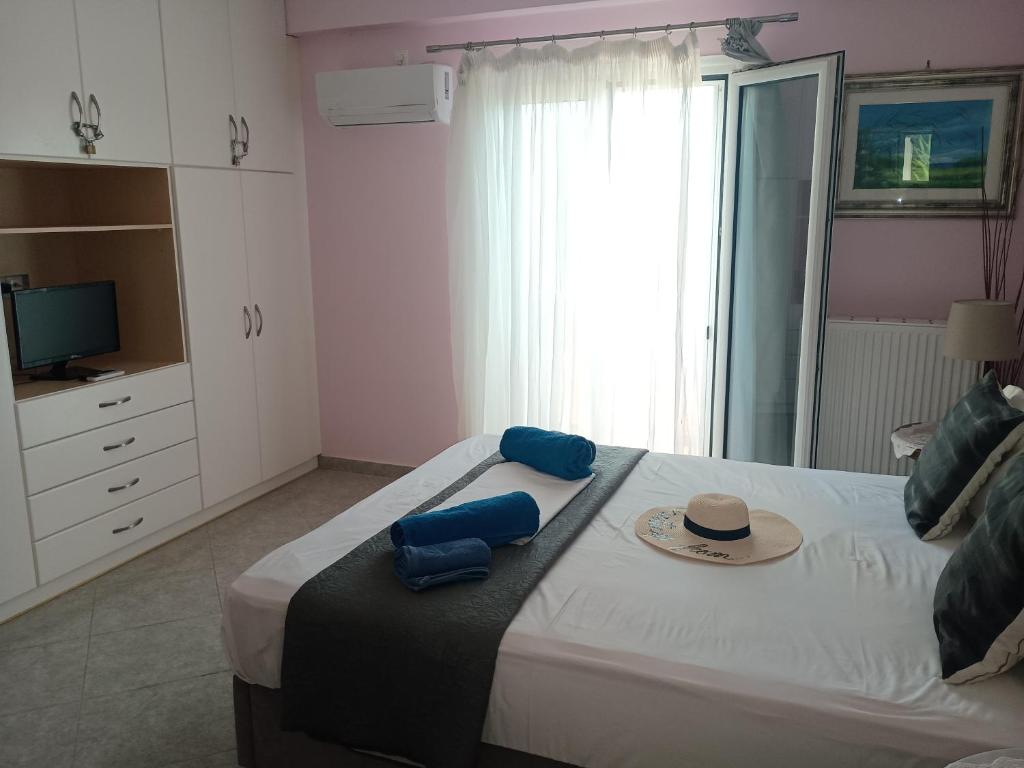 ein Schlafzimmer mit einem Bett, auf dem ein Hut liegt in der Unterkunft Trizinia view balcony in Galatás