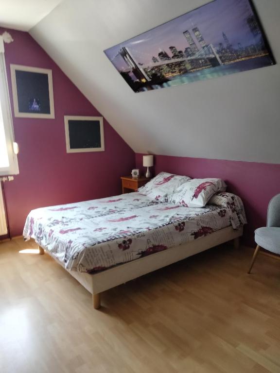 a bedroom with a bed and a purple wall at Bugatti 4 chambres- 4 lits doubles in Teloché