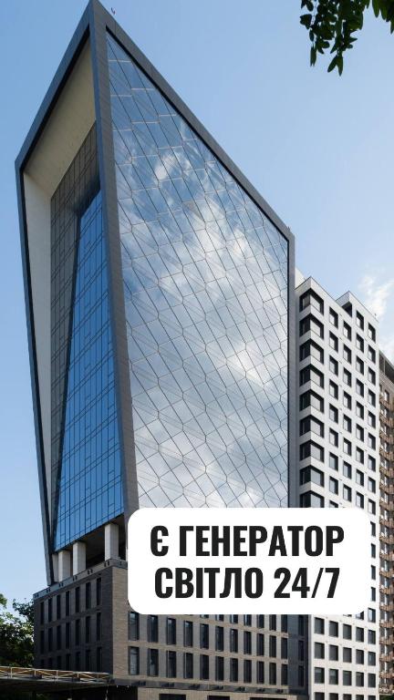 ein hohes Glasgebäude mit einem Schild davor in der Unterkunft BE THE ONE Hotel in Kiew