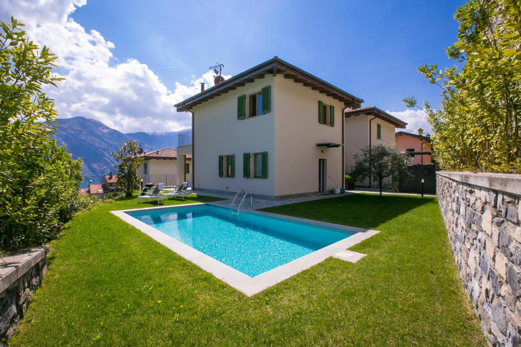 a backyard with a swimming pool and a house at Villa Inti in Tremezzo