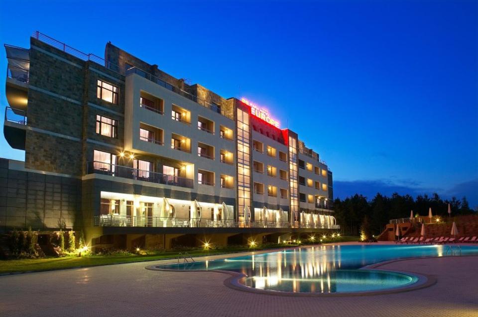um hotel com piscina em frente a um edifício em Park Hotel Green Europe em Haskovo