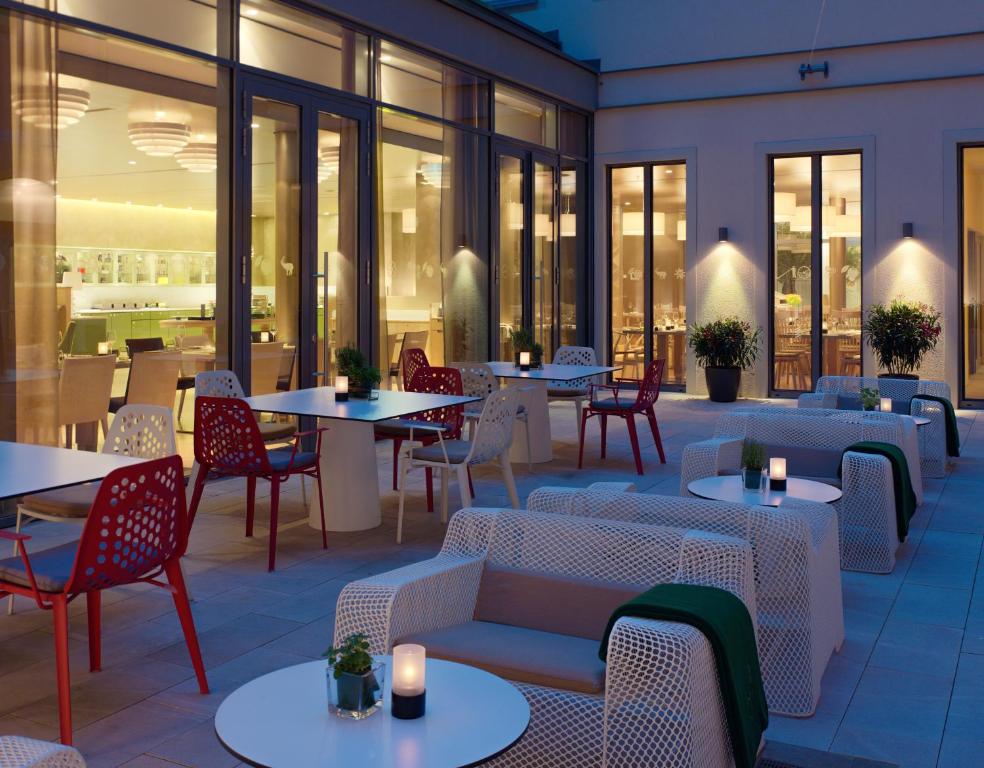 a restaurant with tables and chairs and windows at HYPERION Hotel Dresden Am Schloss in Dresden