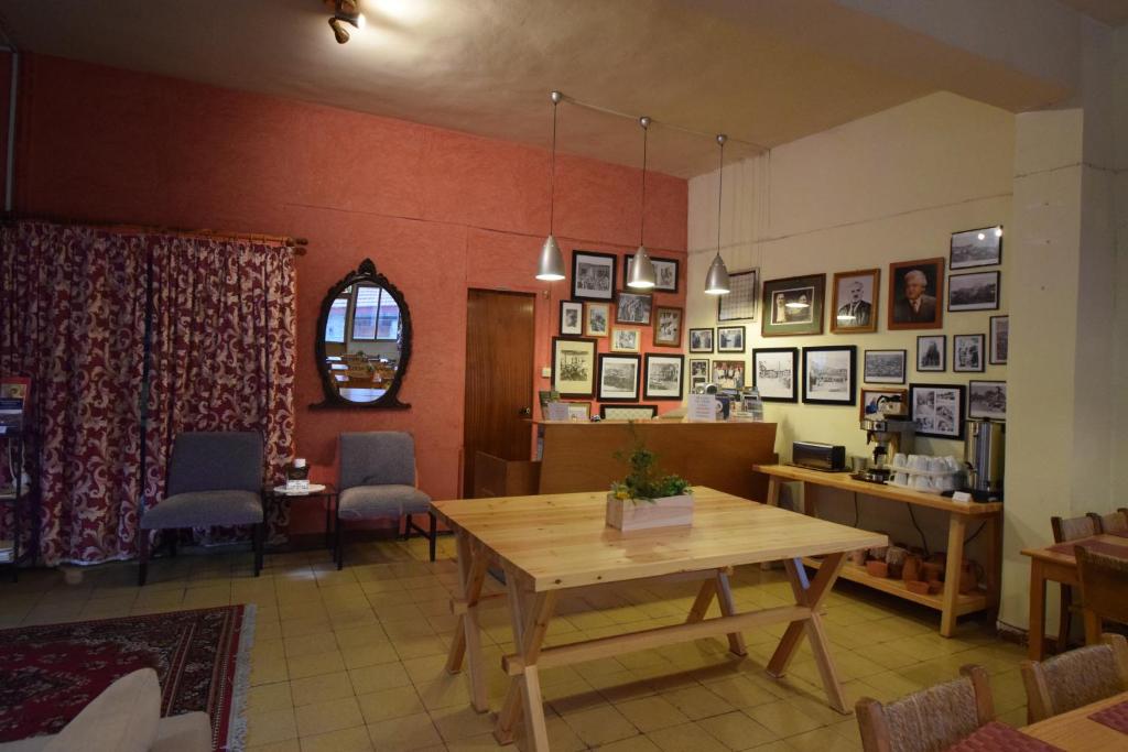 a dining room with a wooden table and chairs at Christys Palace Hotel in Pedoulas