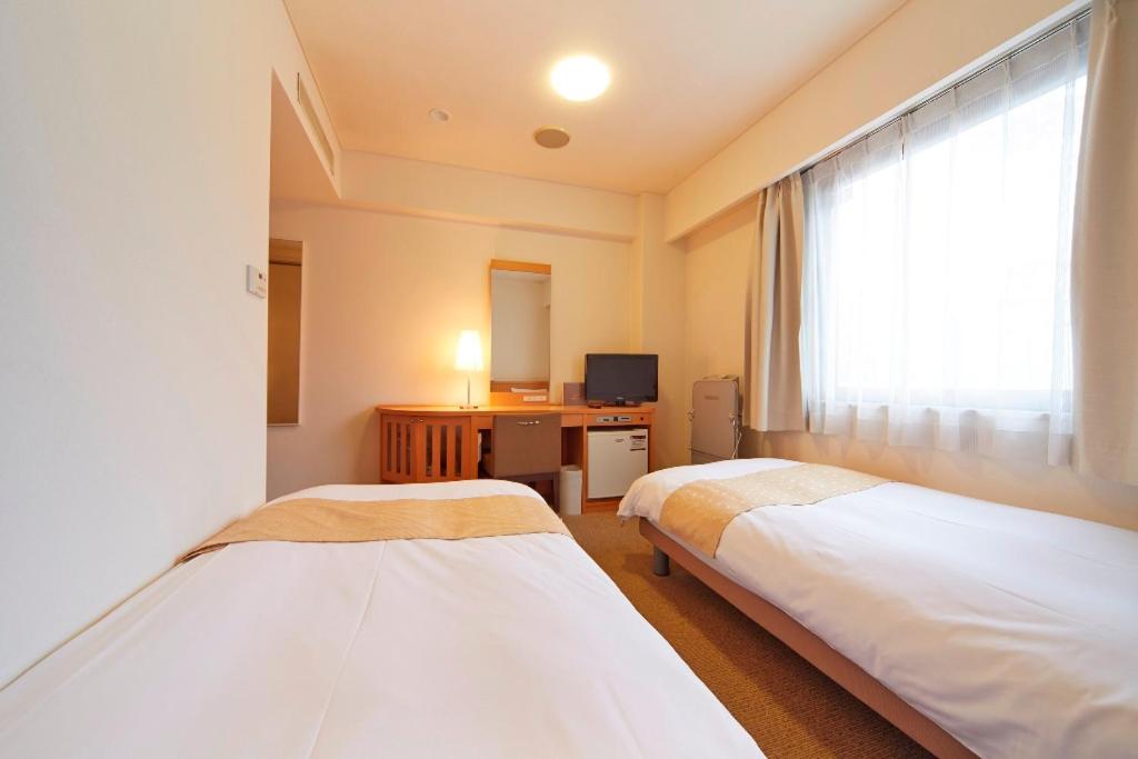 Postel nebo postele na pokoji v ubytování Nest Hotel Kumamoto