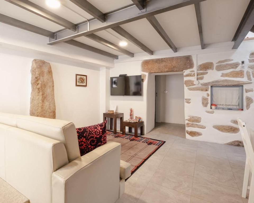 a living room with a couch and a tv at Casa da Caleira in Fonte Arcada