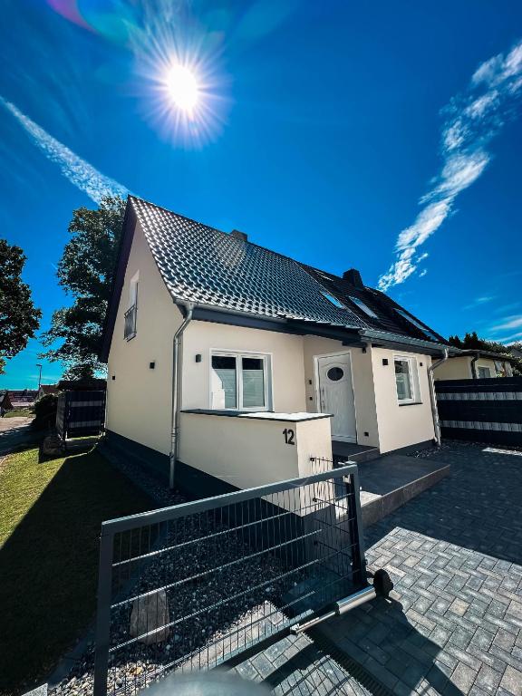 a white house with the sun in the sky at LUMEA Devin in Stralsund