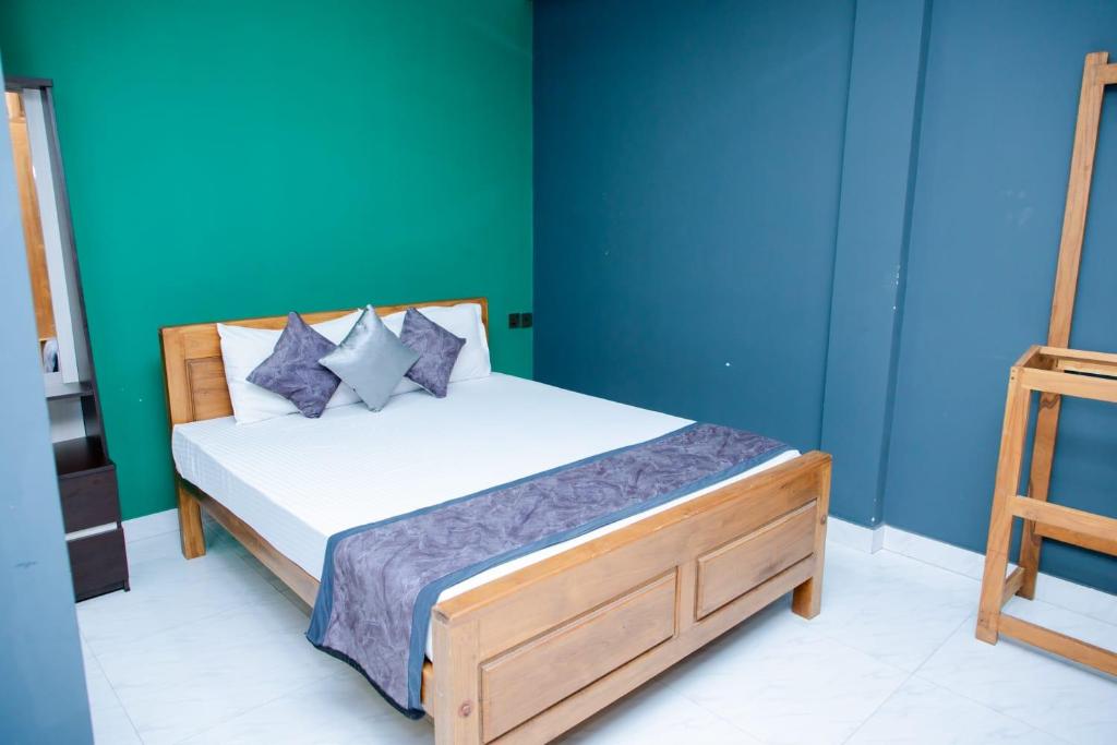 a bedroom with a bed with blue and green walls at JAI REST In in Jaffna