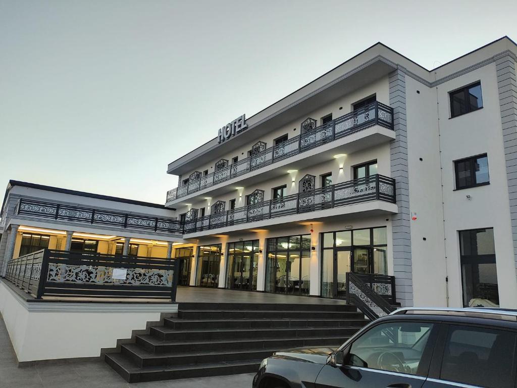 a building with a car parked in front of it at Airport Hotel - Baia Mare - Maramures in Baia Mare