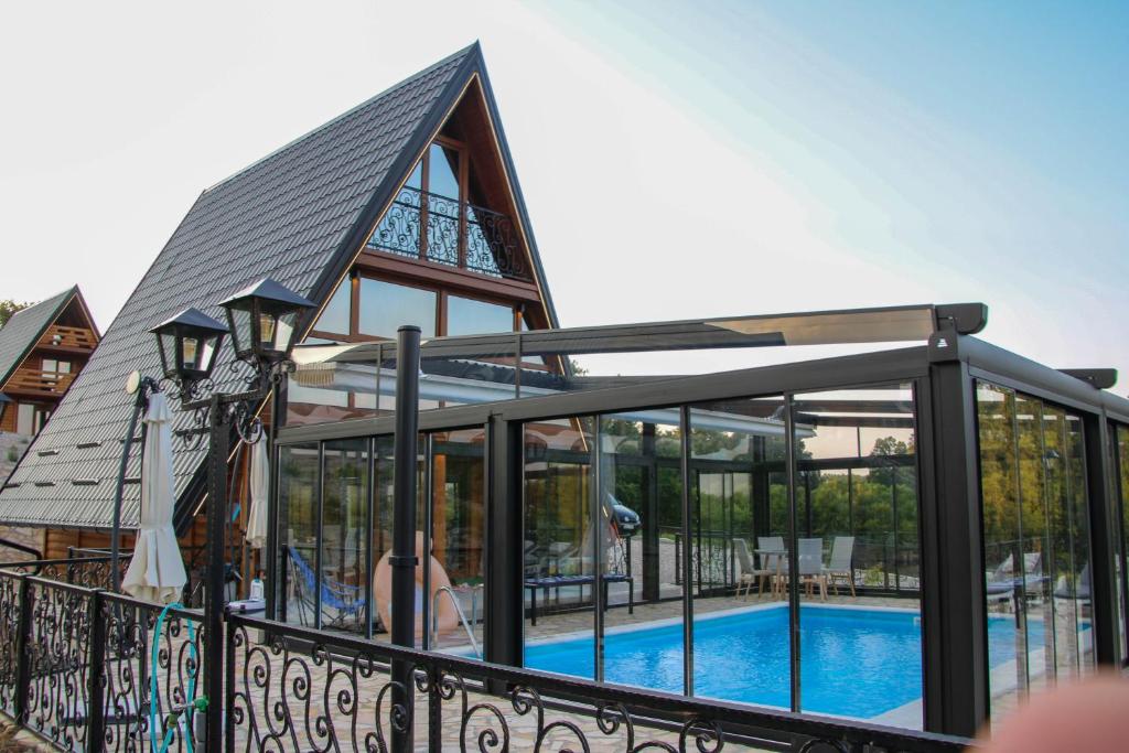 a house with a swimming pool and a roof at Koliba & SPA SlaDjo in Brčko