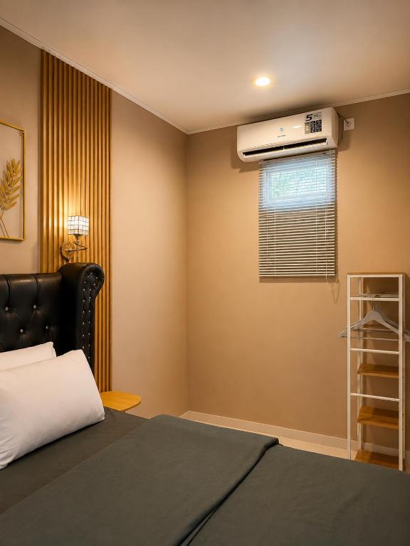 a bedroom with a bed and a air conditioner at Bali Queen Cottage in Pabean Buleleng