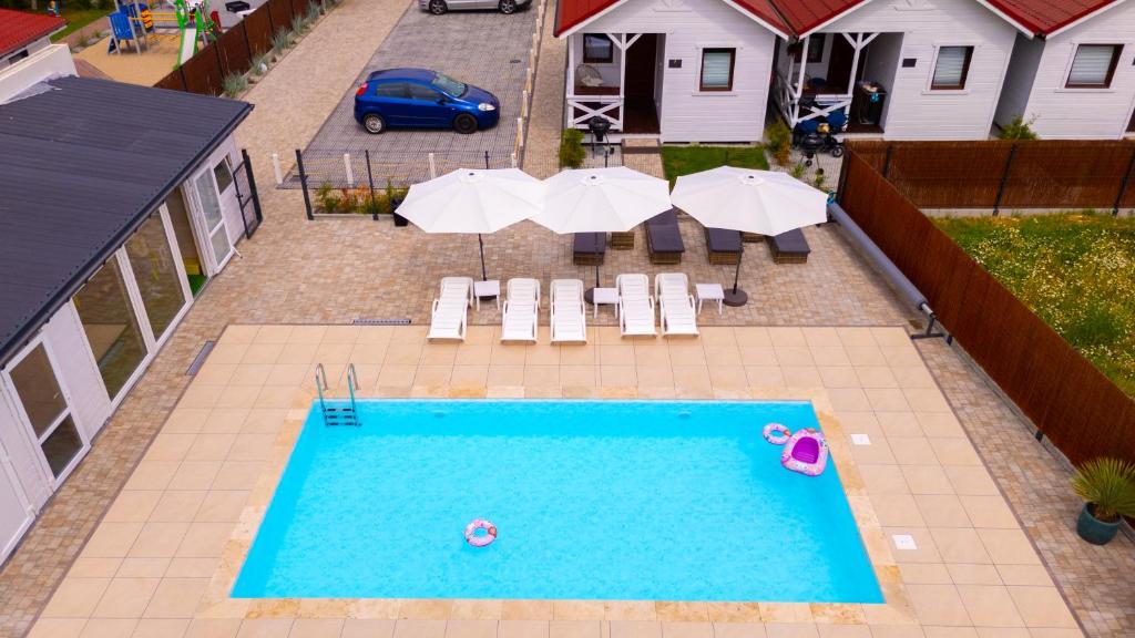 an overhead view of a swimming pool with umbrellas and chairs at Wakacje Bobolin in Bobolin