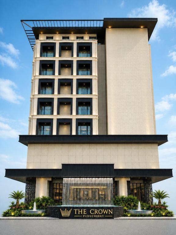 a tall building with a sign in front of it at The Crown Puducherry in Pondicherry