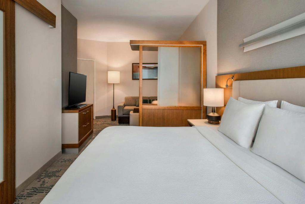 a hotel room with a bed and a television at SpringHill Suites by Marriott Buffalo Airport in Williamsville
