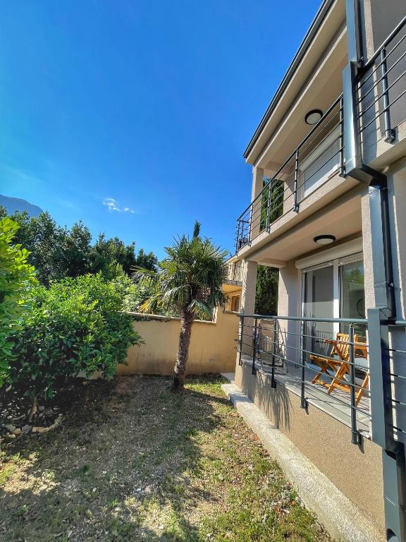 a house with a balcony with a palm tree at Casa Mare in Prčanj