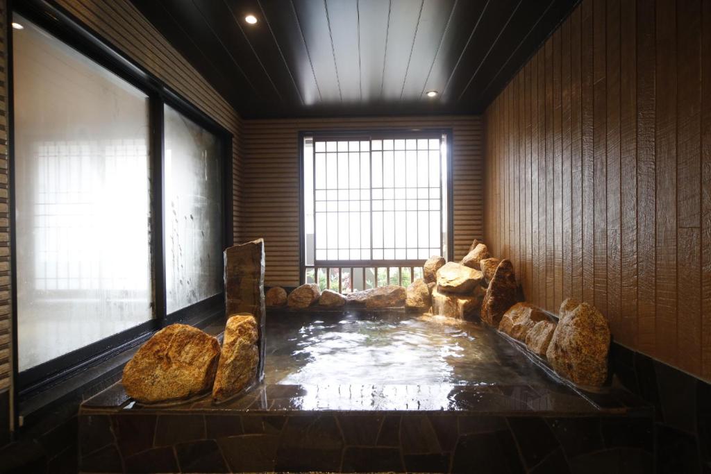 a room with a hot tub in the middle of a room at Dormy Inn Kochi in Kochi