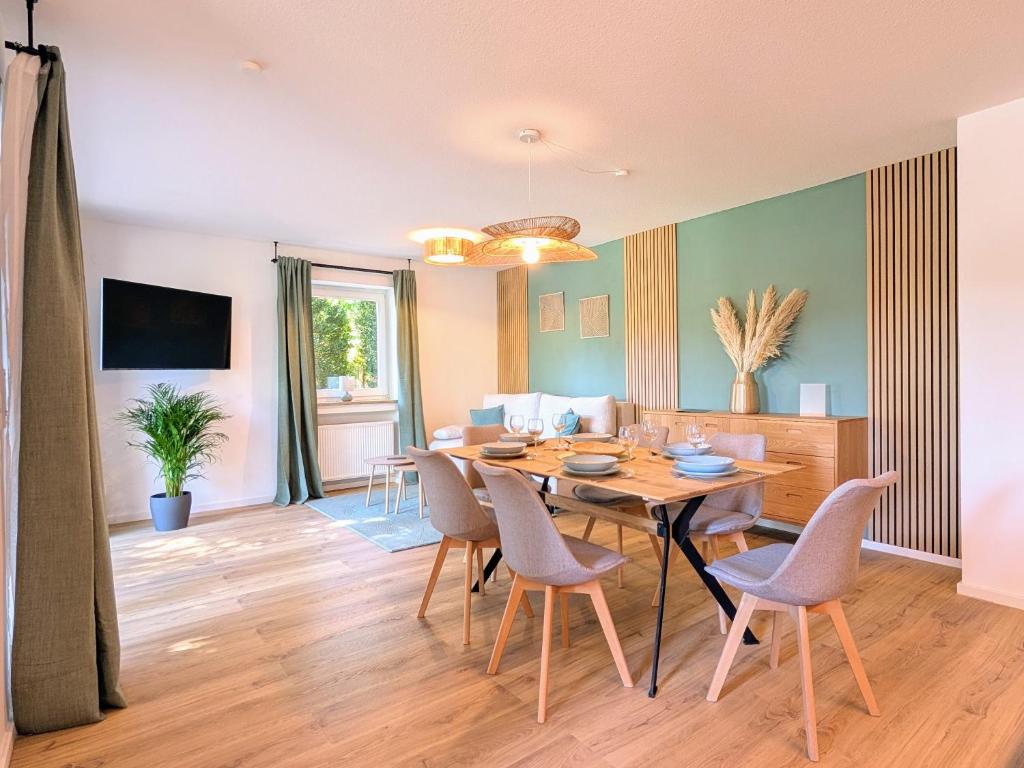 a dining room and living room with a table and chairs at HabeDere Apartments Allgäu in Obergünzburg