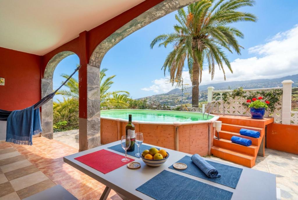 a patio with a hot tub and a table with a bowl of fruit at Vv Casa Marire in Breña Alta
