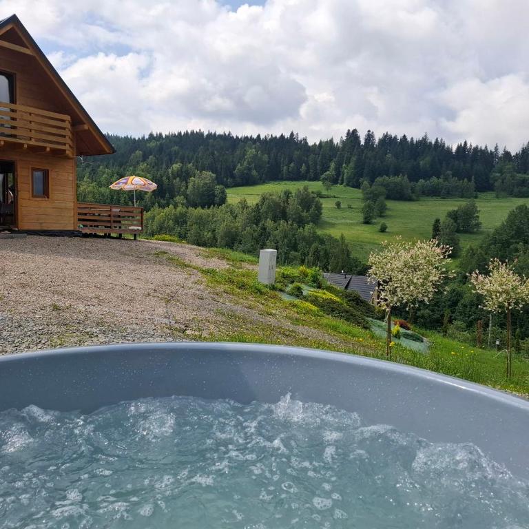 a view from the inside of a hot tub in front of a house at Gładyszówka - Chatka w Gorcach in Ponice