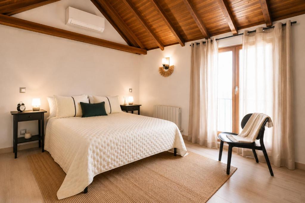 a bedroom with a bed and a chair and a window at Apartamento La Contessina, junto a la Catedral in Toledo