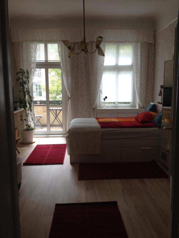 ベルリンにあるAppartement am Tegeler Seeのベッドと大きな窓のある寝室