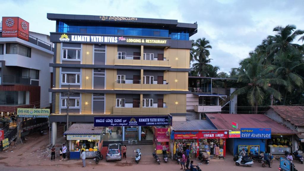 a large building with people walking in front of it at Kamath Yatri Nivas Plus in Māvalli