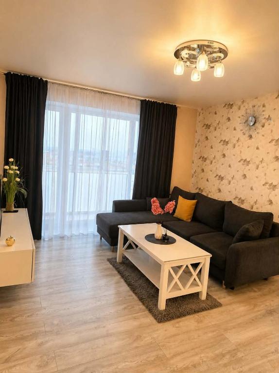 a living room with a couch and a table at Apartment in Telšiai