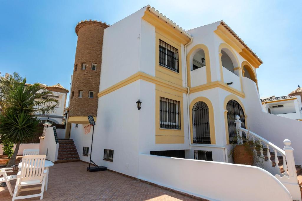 a white and yellow building with two towers at house las chuchas CALAHONDA in Motril