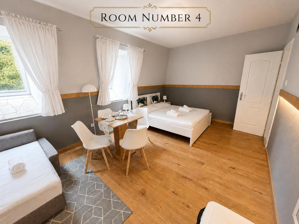 a room with a bed and a table and chairs at Castle Park Suites in Hermina-major