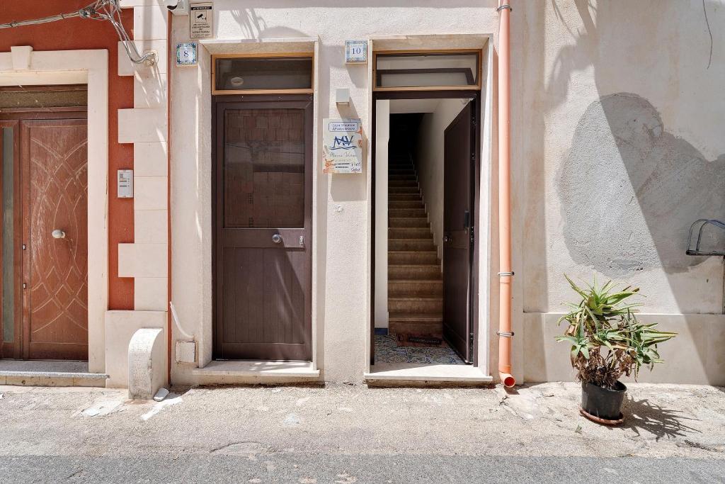 an open door of a building with a staircase at Maison Vivian Rooms in Marzamemi
