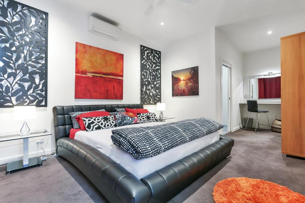 a bedroom with a leather bed and a couch at Barossa White House The West Wing in Angaston