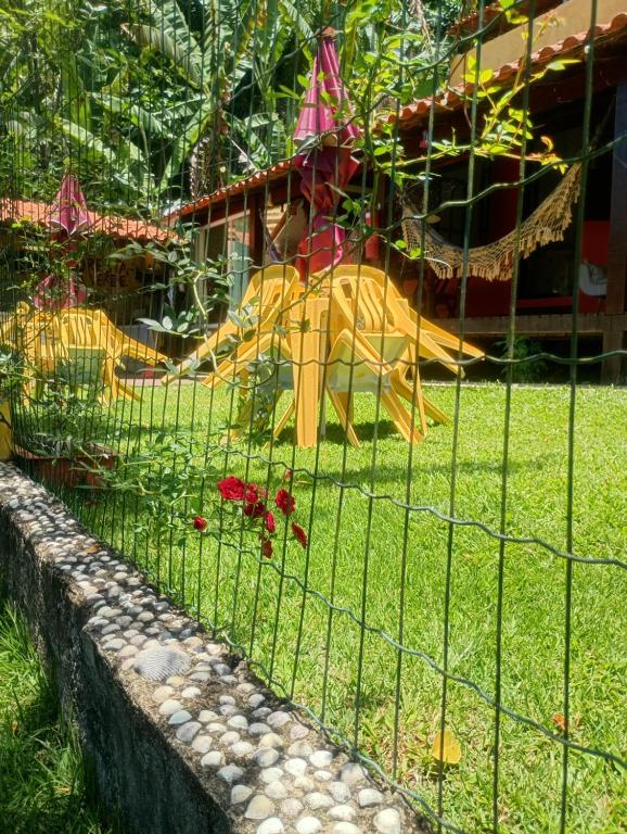 a playground with a yellow slide in the grass at Suíte simples floresta verde in Angra dos Reis