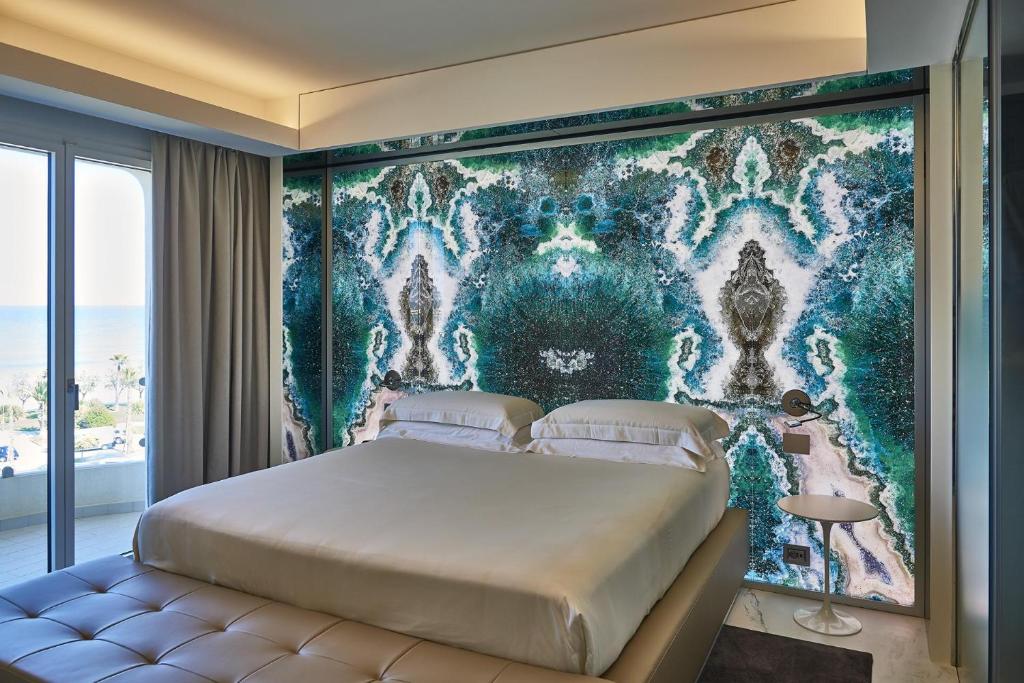 a bedroom with a bed and a wall mural at Ghibli Boutique Hotel Civitanova Marche in Civitanova Marche