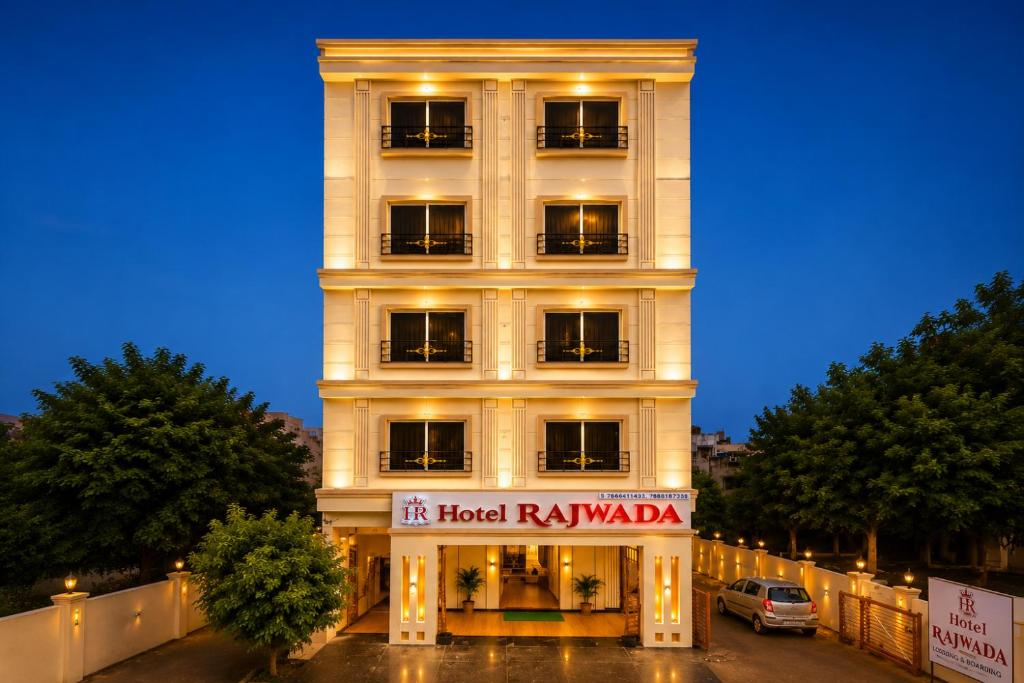 a tall white building with a sign on it at Hotel Rajwada Nagpur in Nagpur