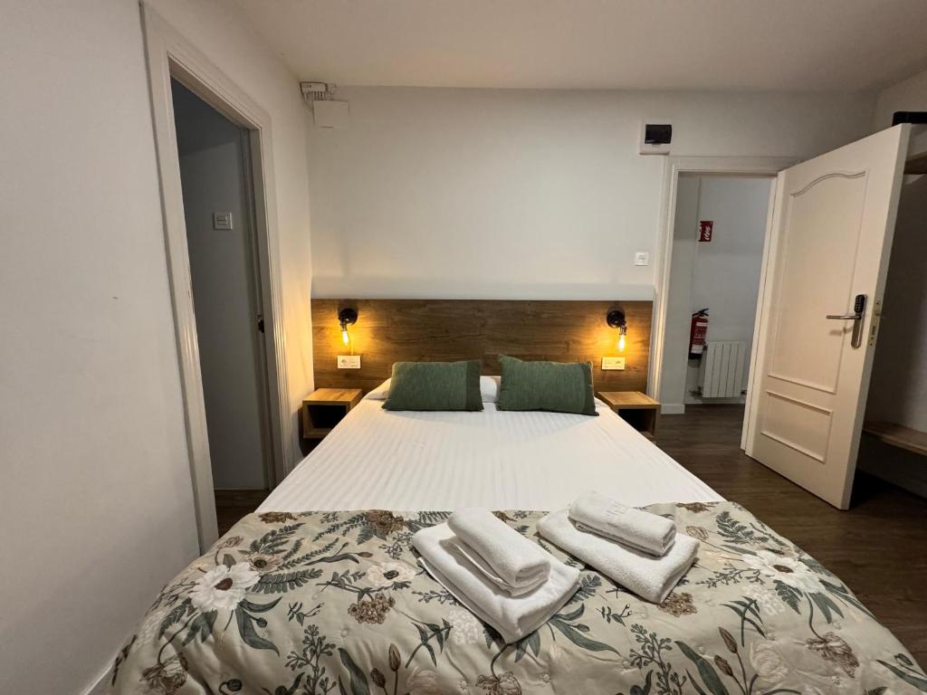 a bedroom with a large bed with two towels on it at IRUÑA ROOMs in Pamplona