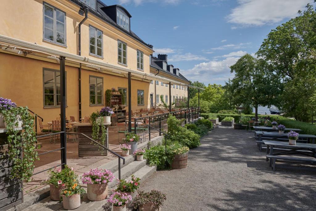 a building with potted plants and tables and benches at Hotel Skeppsholmen, Stockholm, a Member of Design Hotels in Stockholm