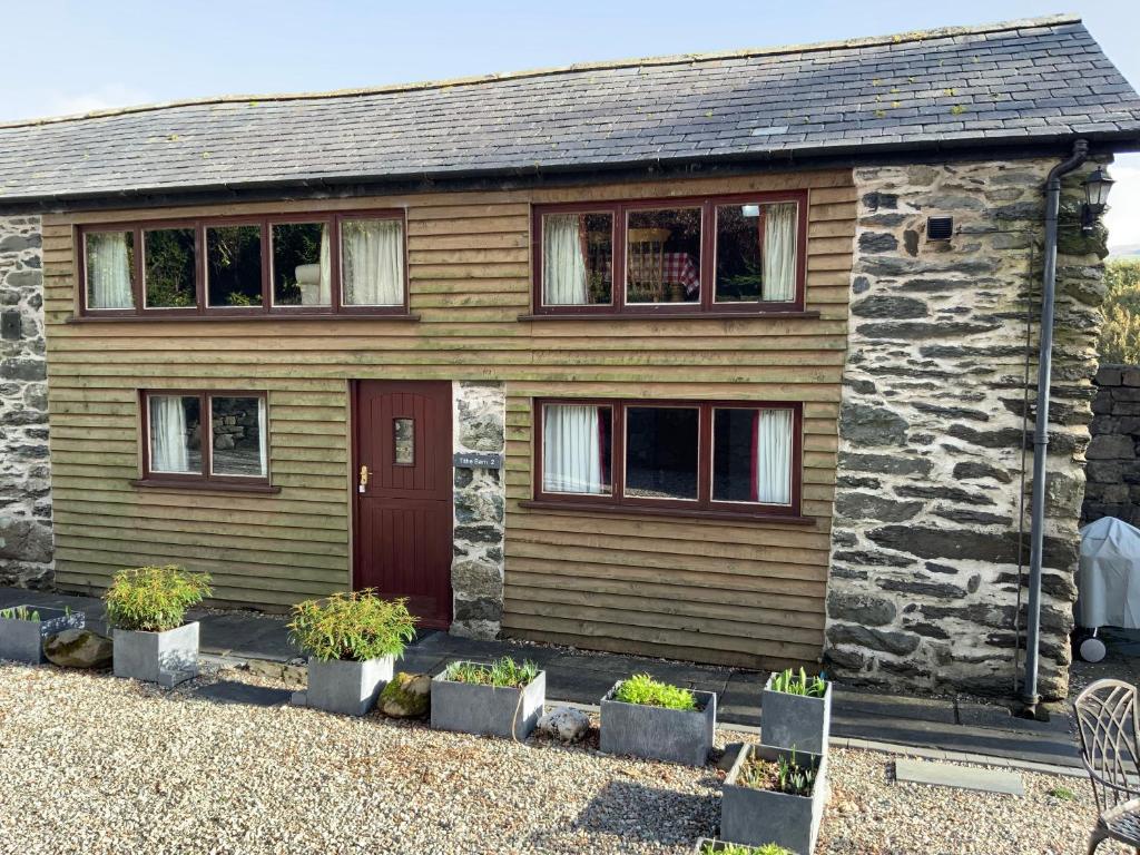 a stone house with a red door at Tithe Barn 2 - Abercelyn Cottages - Llanycil - Bala - Gwynedd - LL23 7YF - UK in Llanycil