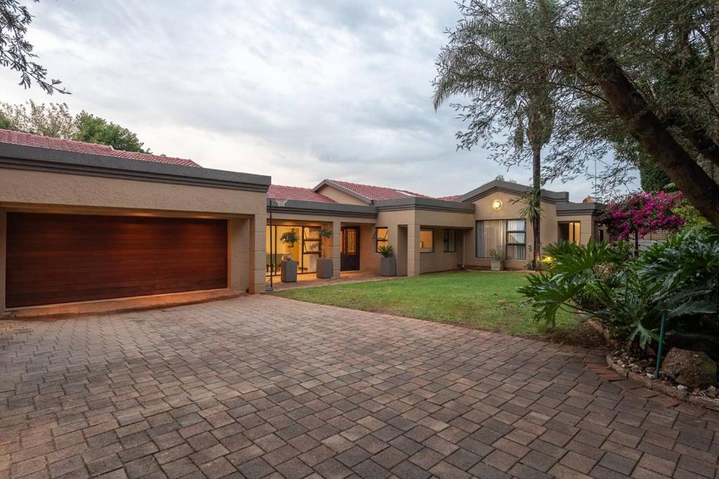 a house with a garage and a brick driveway at Mancave Luxury Homes in Alberton