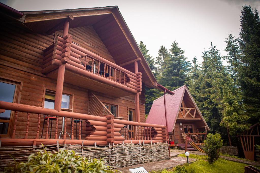 a large wooden house with a balcony and a porch at Бойківський двір in Yasenitsa Zamkova