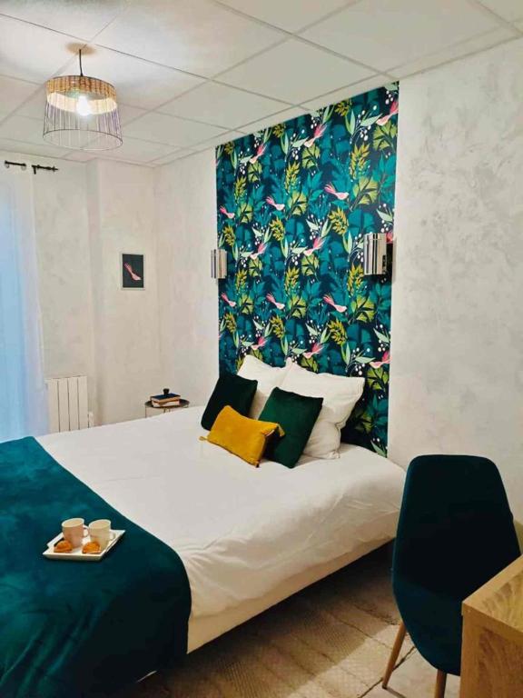 a bedroom with a large bed with a blue and green wallpaper at Savana Lodge, Wi-Fi, Parking Privé et Calme, Sortie 12 ChanaS in Chanas