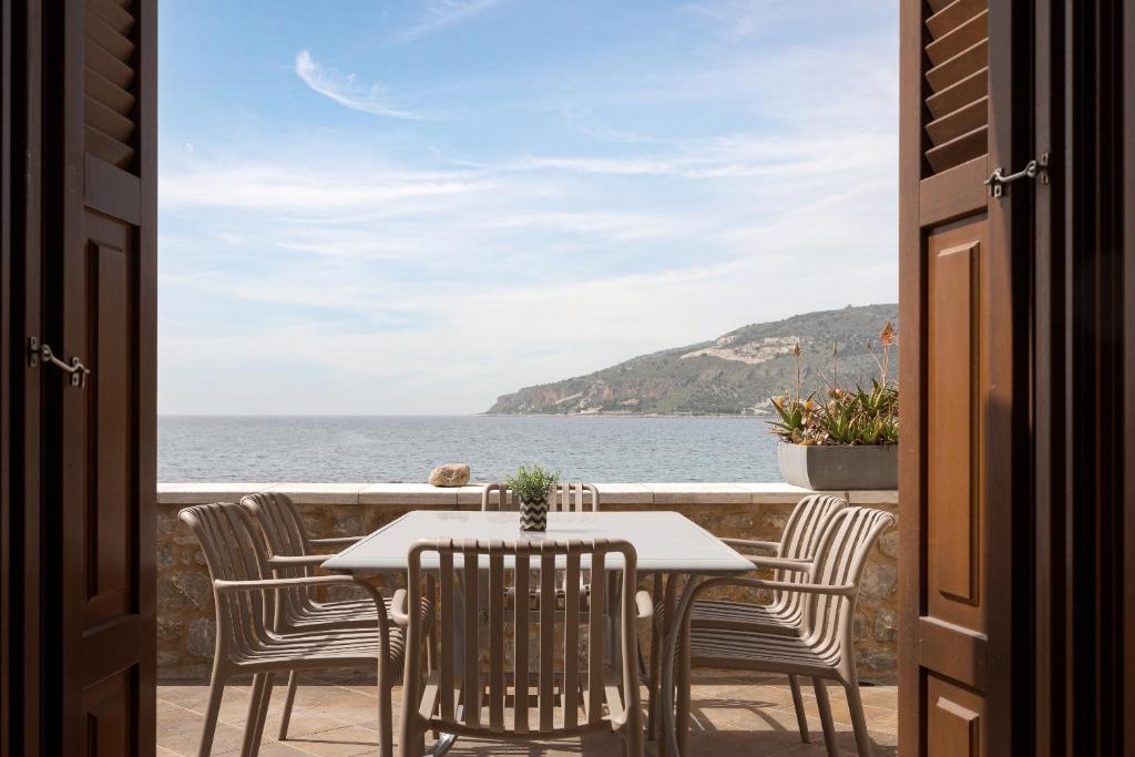 a table and chairs with a view of the ocean at Aura Seafront Villa in Neo Itilo