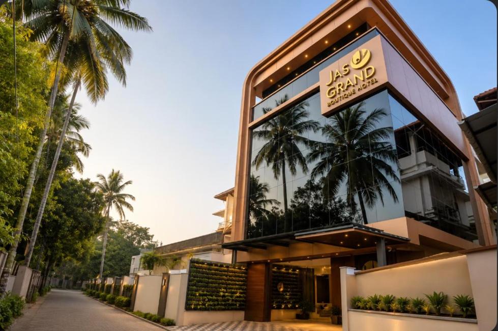 a building with palm trees on the side of it at Jas Grand Inn in Cochin