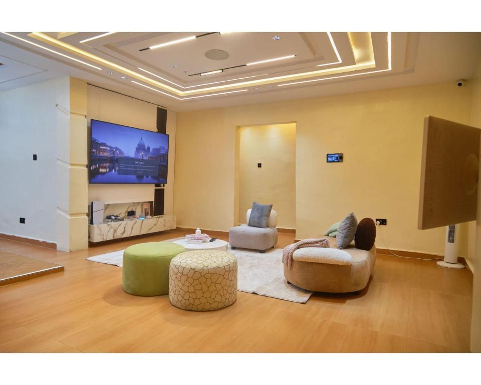 a living room with two chairs and a flat screen tv at Capediem luxury apartment in Oba Ile