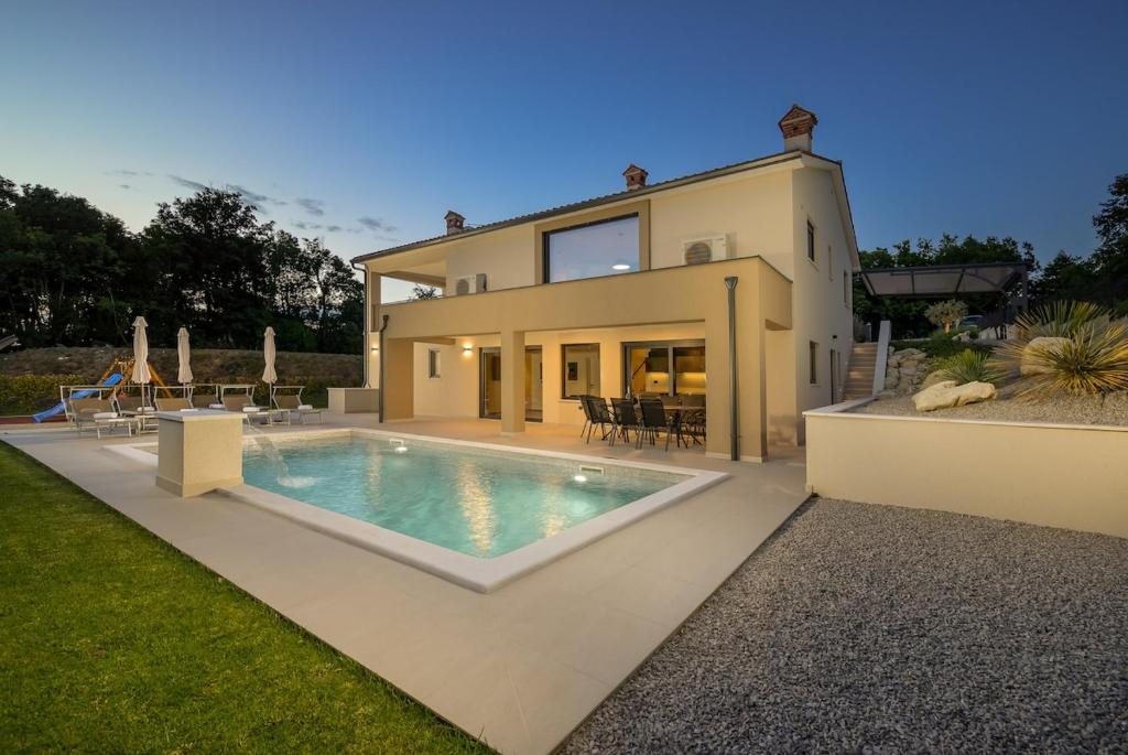 a house with a swimming pool in front of it at Villa Mochi by IstriaLux in Pićan