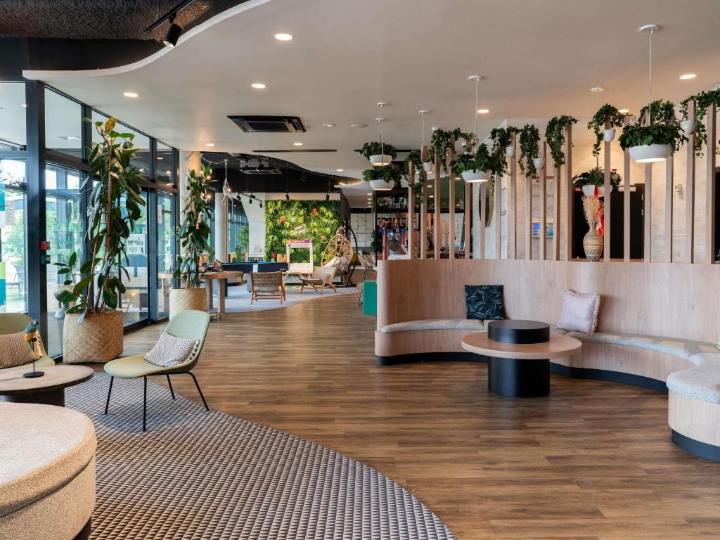 a lobby with tables and chairs and potted plants at ibis budget Rouen Centre Rive Gauche in Rouen