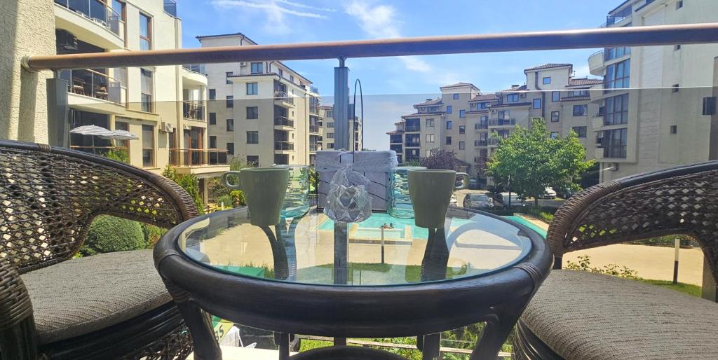 a glass table on a balcony with two chairs at Sun Sea 1 studio sea view in Shkorpilovtsi