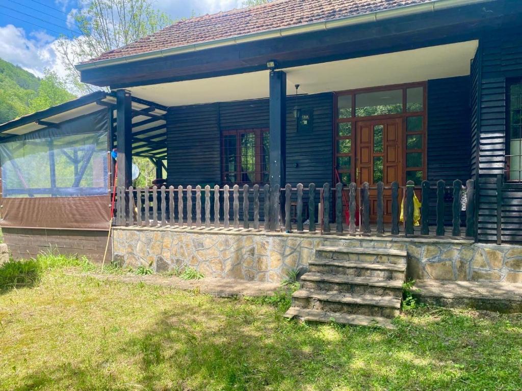 a blue house with a fence in front of it at Weekend House in Vrelo in Jelovica