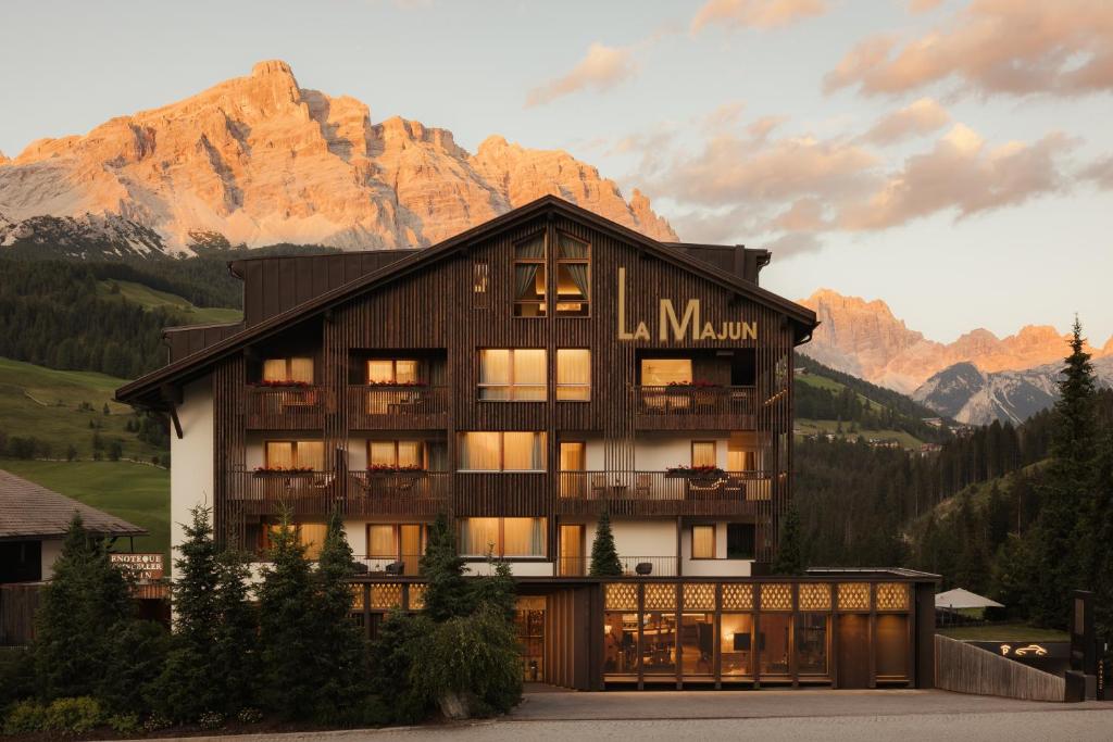 a large building with mountains in the background at Hotel La Majun in La Villa
