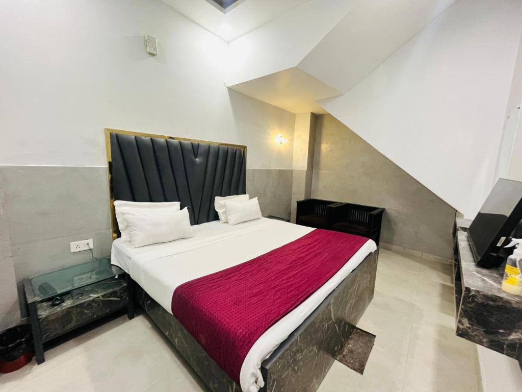 a bedroom with a large bed with a red blanket at Hotel Royal Residency - Laxmi Nagar in New Delhi