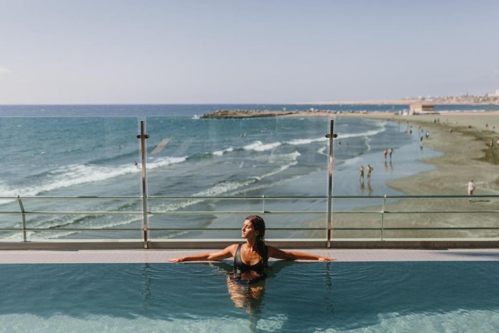 a woman in a swimming pool next to the beach at Don Gregory by Dunas - Adults Only in San Agustin