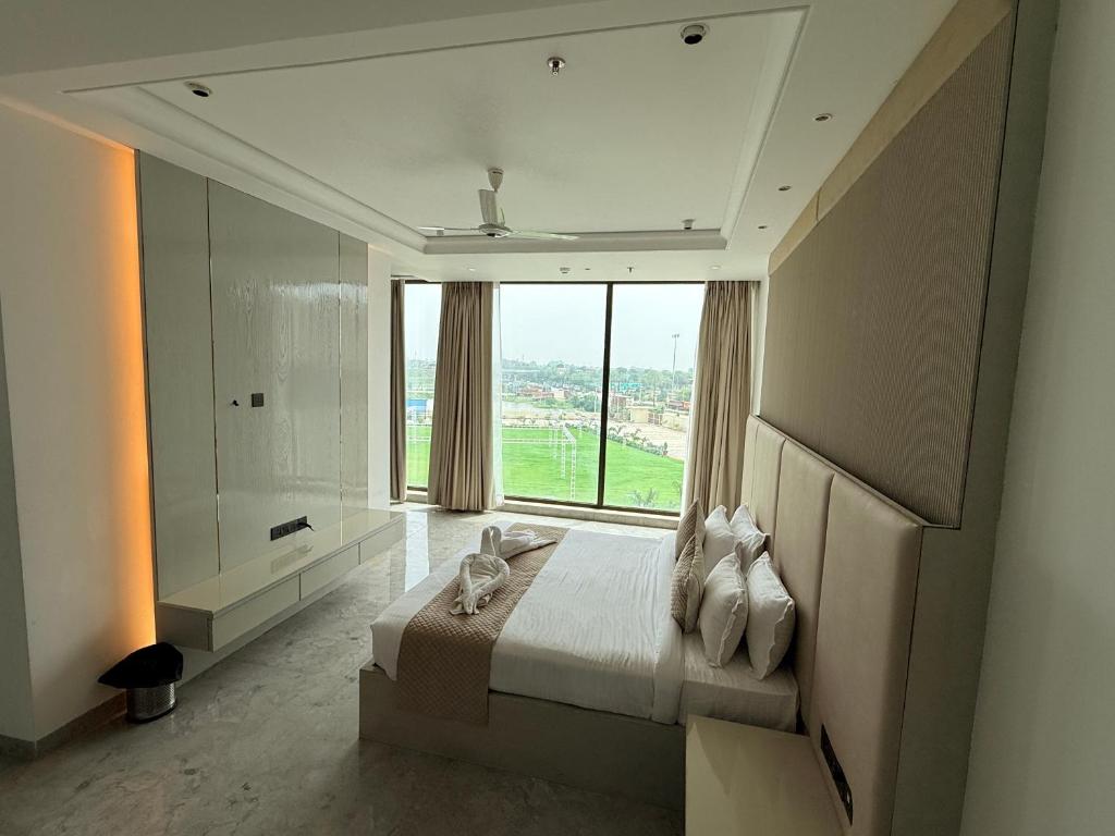 a bedroom with a bed and a large window at Bhola Resort in Soraon